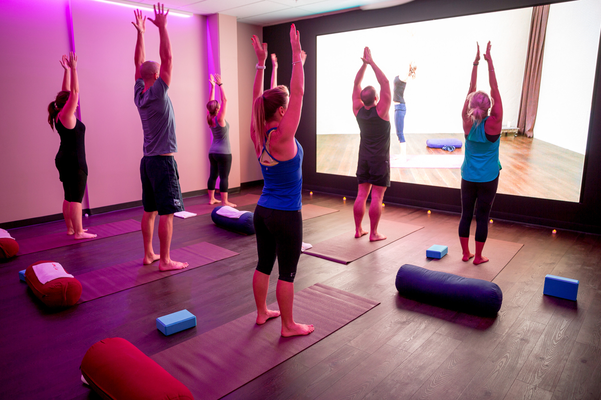 People doing group fitness in front of a large screen